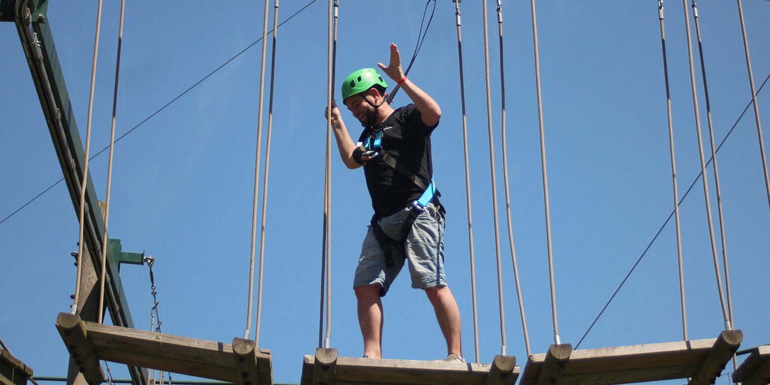 A man walking on the adventurous high ropes in Sandwell valley country park